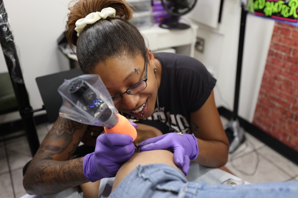 Kristen Raymond works on a tattoo in her Allentown shop, Herb N Ink.